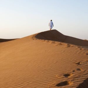 InstyleTouristik_Omani man walking on dunes © Ministry of Heritage & Tourism Sultanate of Oman copy 2