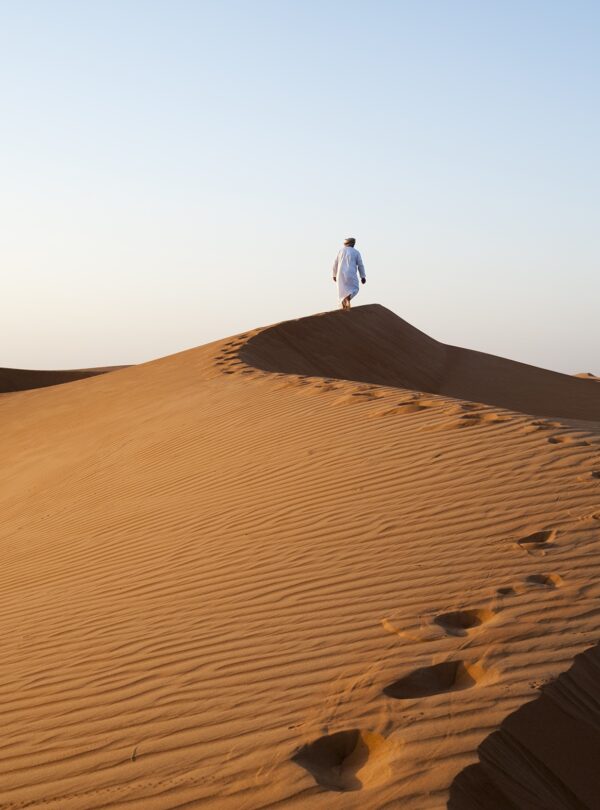 Omani man walking on dunes © Ministry of Heritage & Tourism Sultanate of Oman copy 2